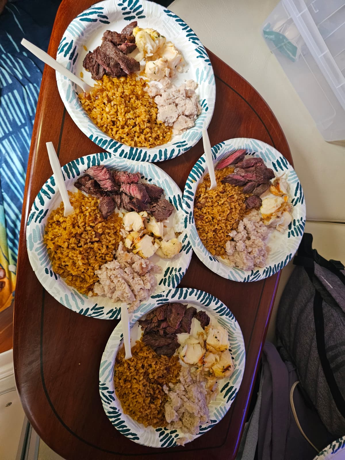 Plated charter lunch with grilled steak, rice, and lobster served onboard for the group