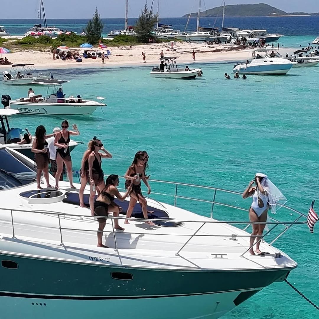 Yacht arriving at busy sandbar with bachelorette group on the bow