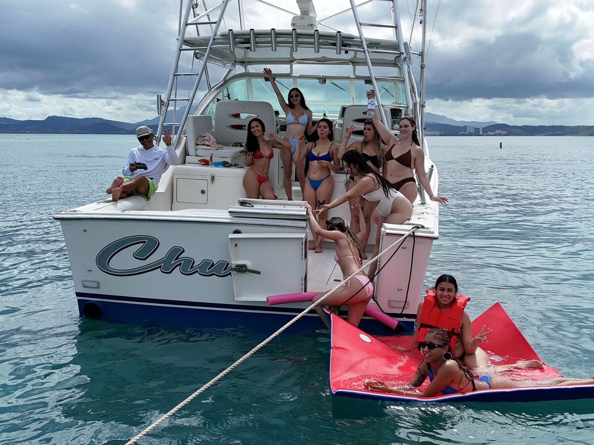 Bride Squad bachelorette group celebrating on the bow of a private yacht in turquoise Caribbean water near Fajardo, Puerto Rico