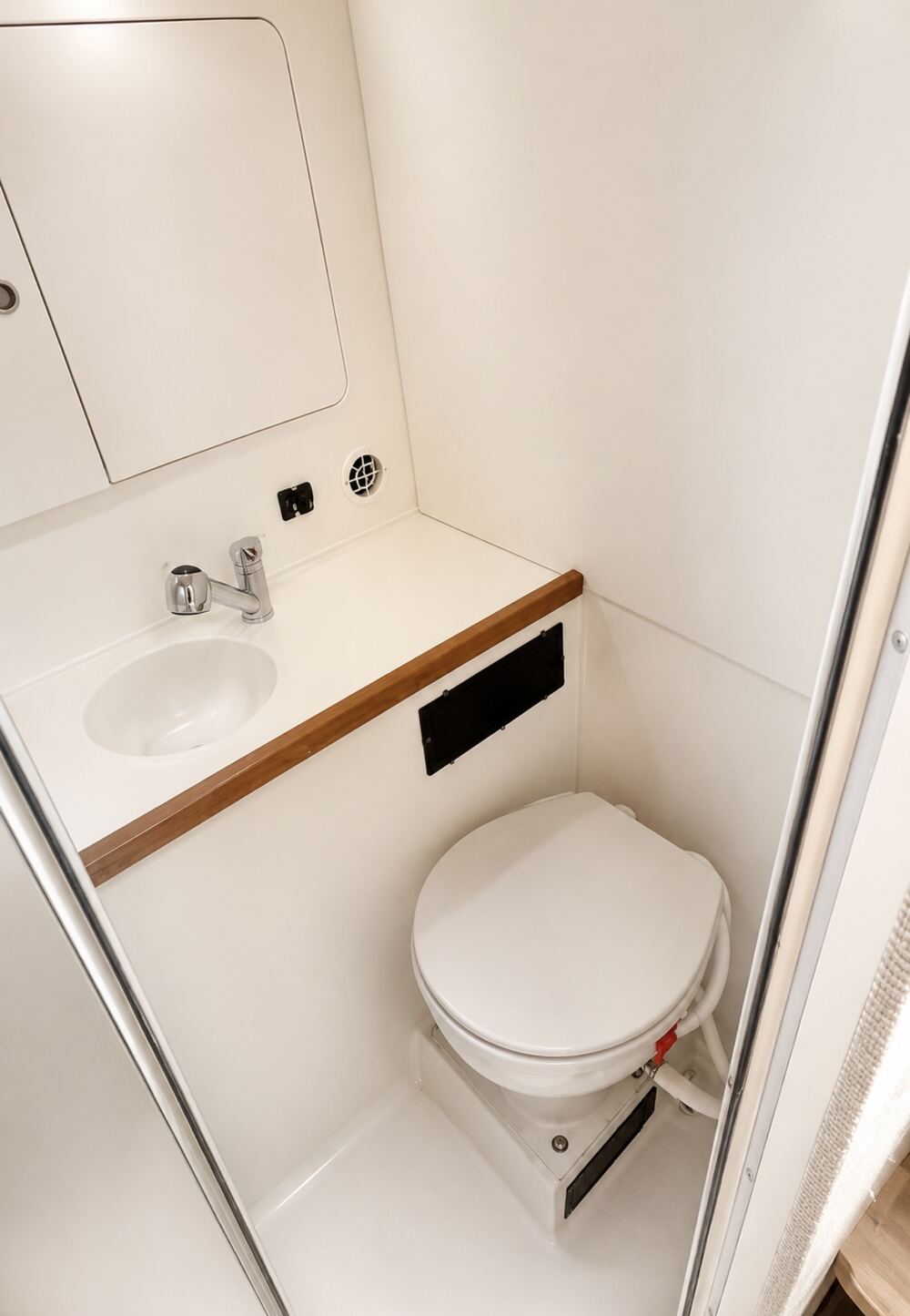 Enclosed head on the Contender 38 with sink, running water, mirror and chrome fixtures