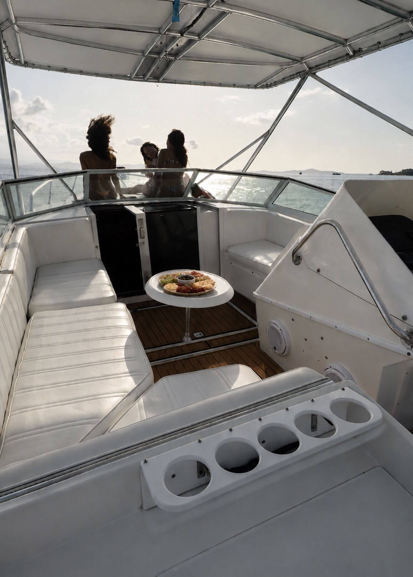 Guests on the bow of the Contender 38 at sunset with a cheese and fruit board on the cockpit table, off Fajardo, Puerto Rico