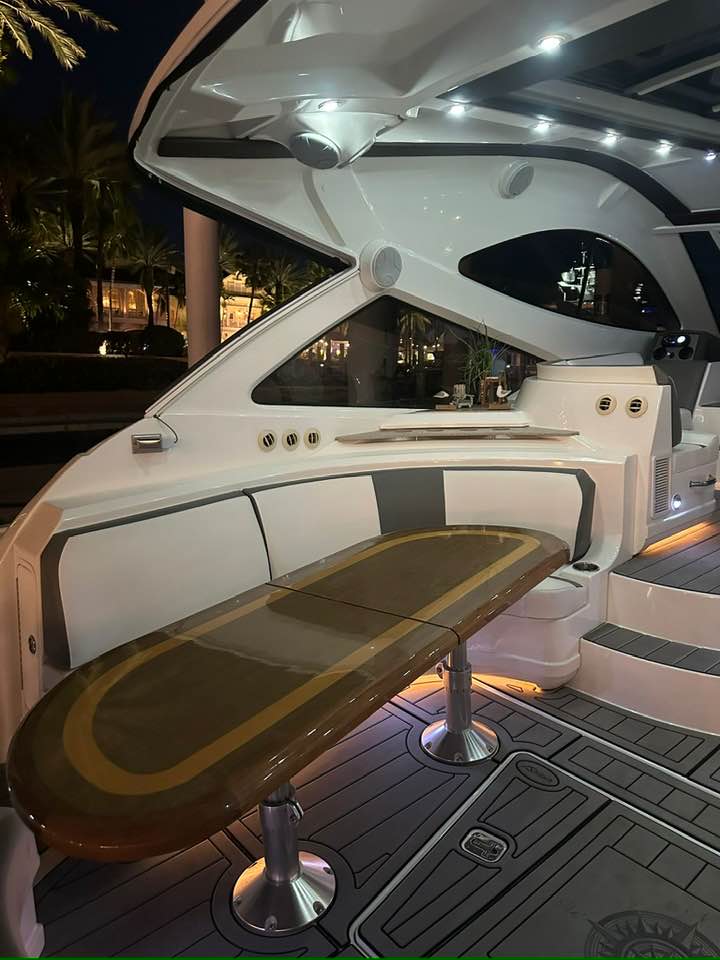 Cruiser Yachts 60 aft deck with teak dining table at night, Fajardo marina