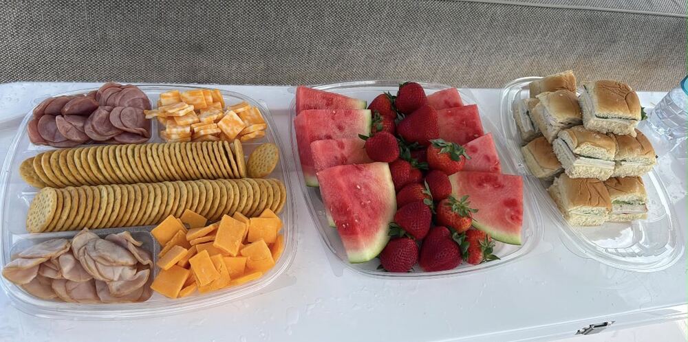 Charcuterie tray with deli meats, cheese cubes and crackers, fresh watermelon and strawberries, and brioche slider sandwiches served on board a private charter in Fajardo, Puerto Rico