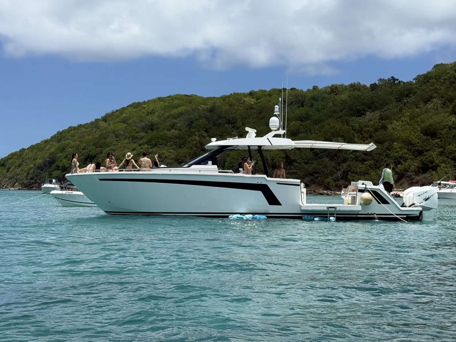 Group celebrating on the bow of an Ocean Alexander yacht anchored at a Caribbean sandbar