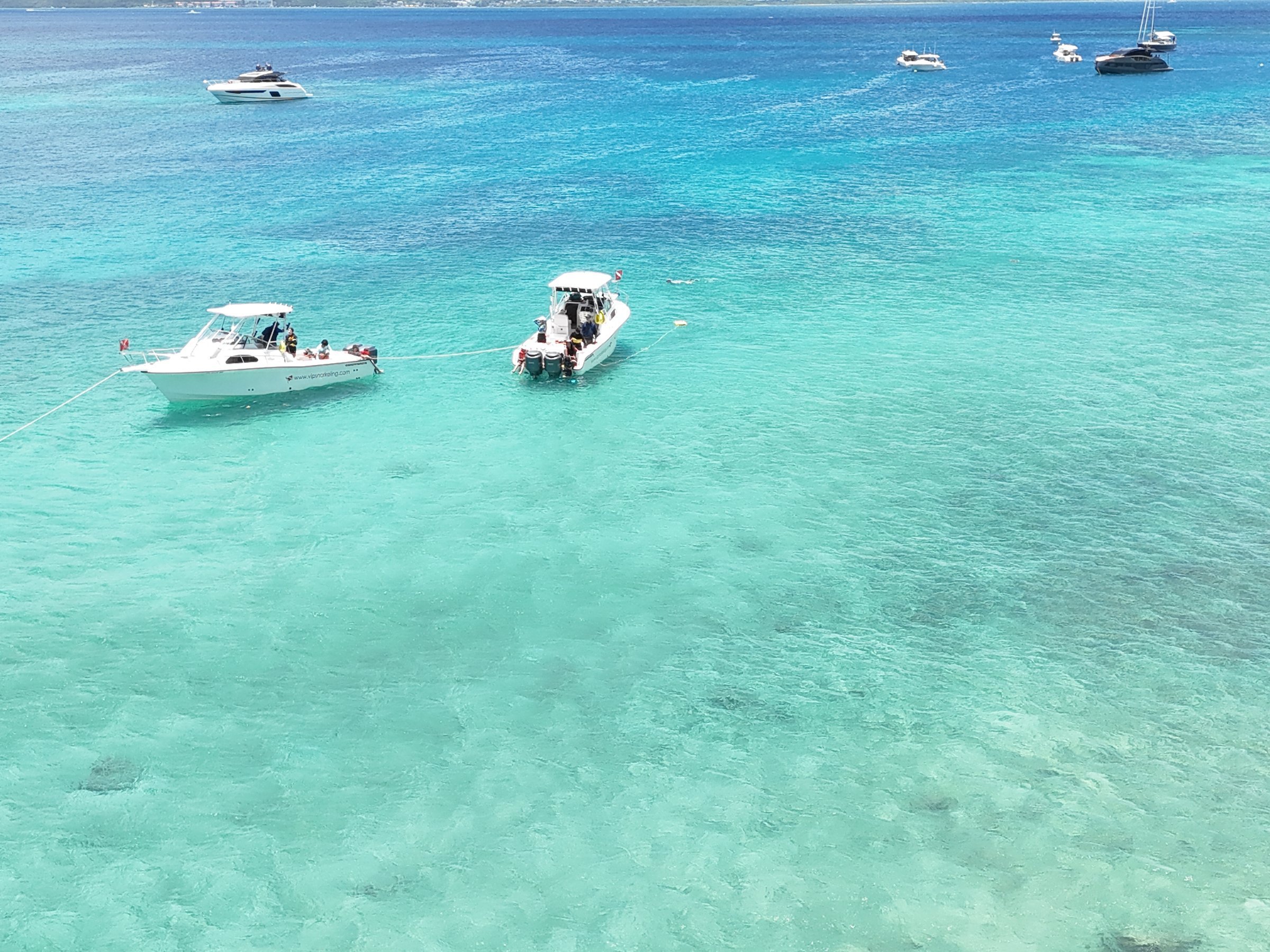 Aerial of two charter boats in crystal-clear turquoise Caribbean water