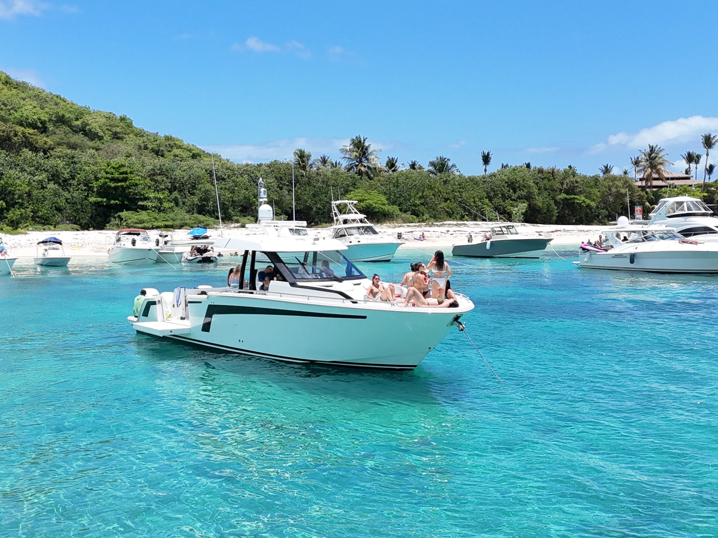 Group of guests relaxing on the bow of an Axopar charter at the Icacos sandbar