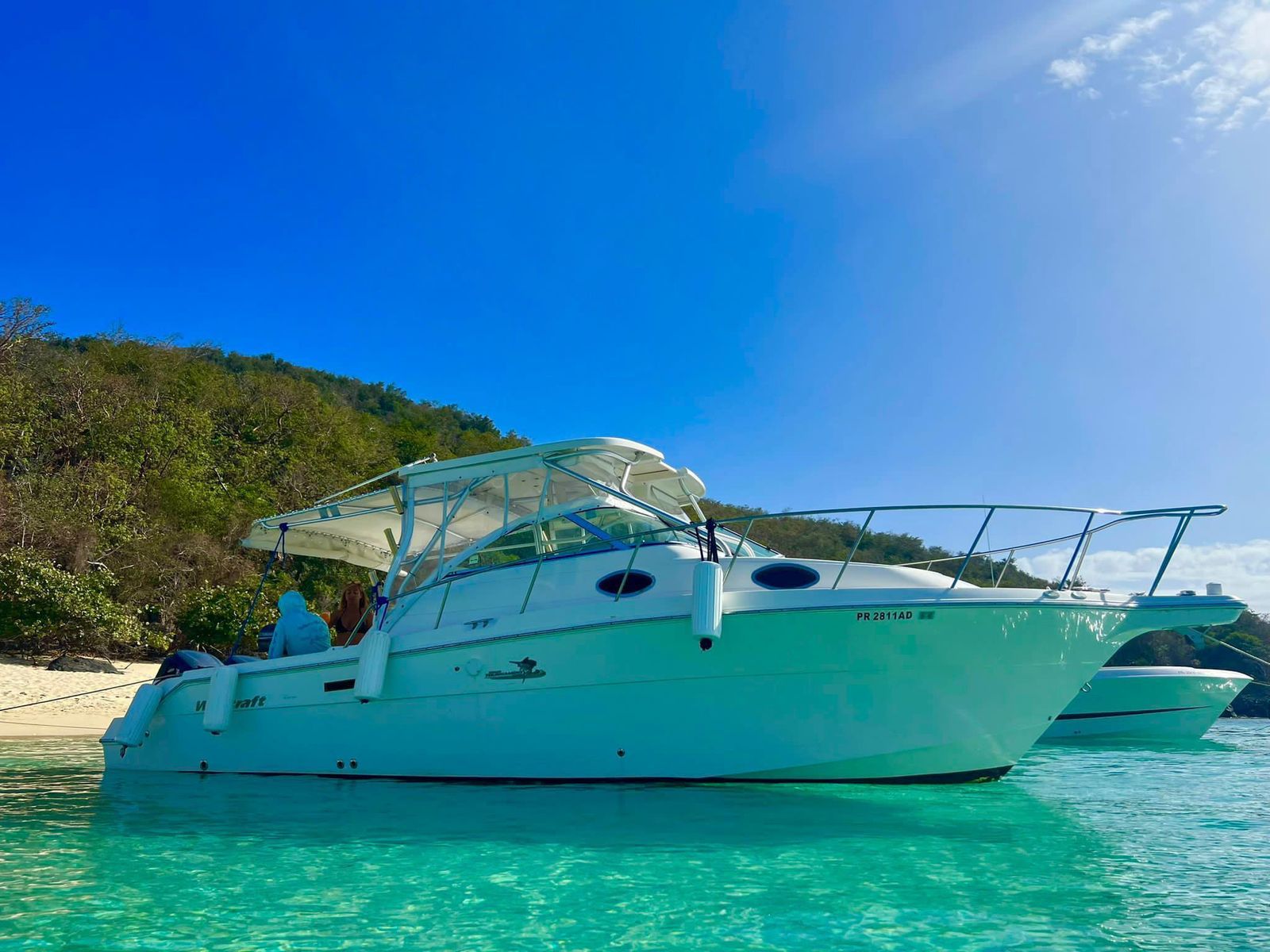 Wellcraft 30 anchored off the Caribbean shoreline with another boat alongside